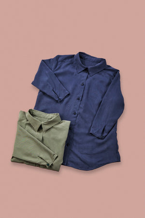 blue blouse and folded up green blouse on rose background