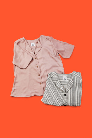 rose blouse and folded up striped blouse on orange red background