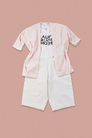 matching pastel pink outfit with white shirt on rose background