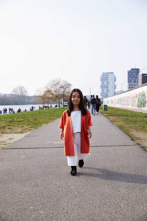 woman with dwarfism walking down east side gallery in berlin in tailored outfit