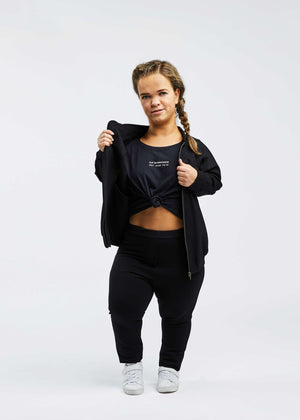 woman with dwarfism wearing black college jacket and sport outfit