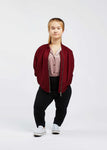 woman with dwarfism wearing wine red college jacket and cool outfit