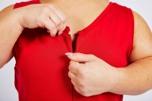 woman with dwarfism zipping up her bright red jumpsuit