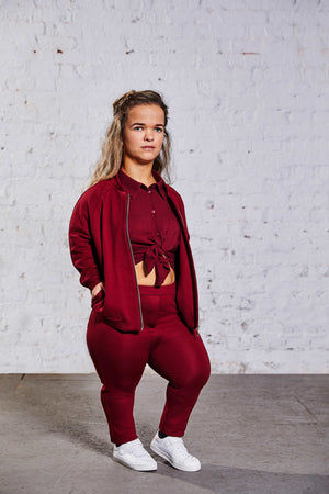woman with dwarfism wearing a monochrome outfit in wine red
