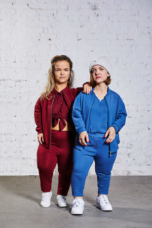 two women with dwarfism wearing monochromatic red and blue outfits