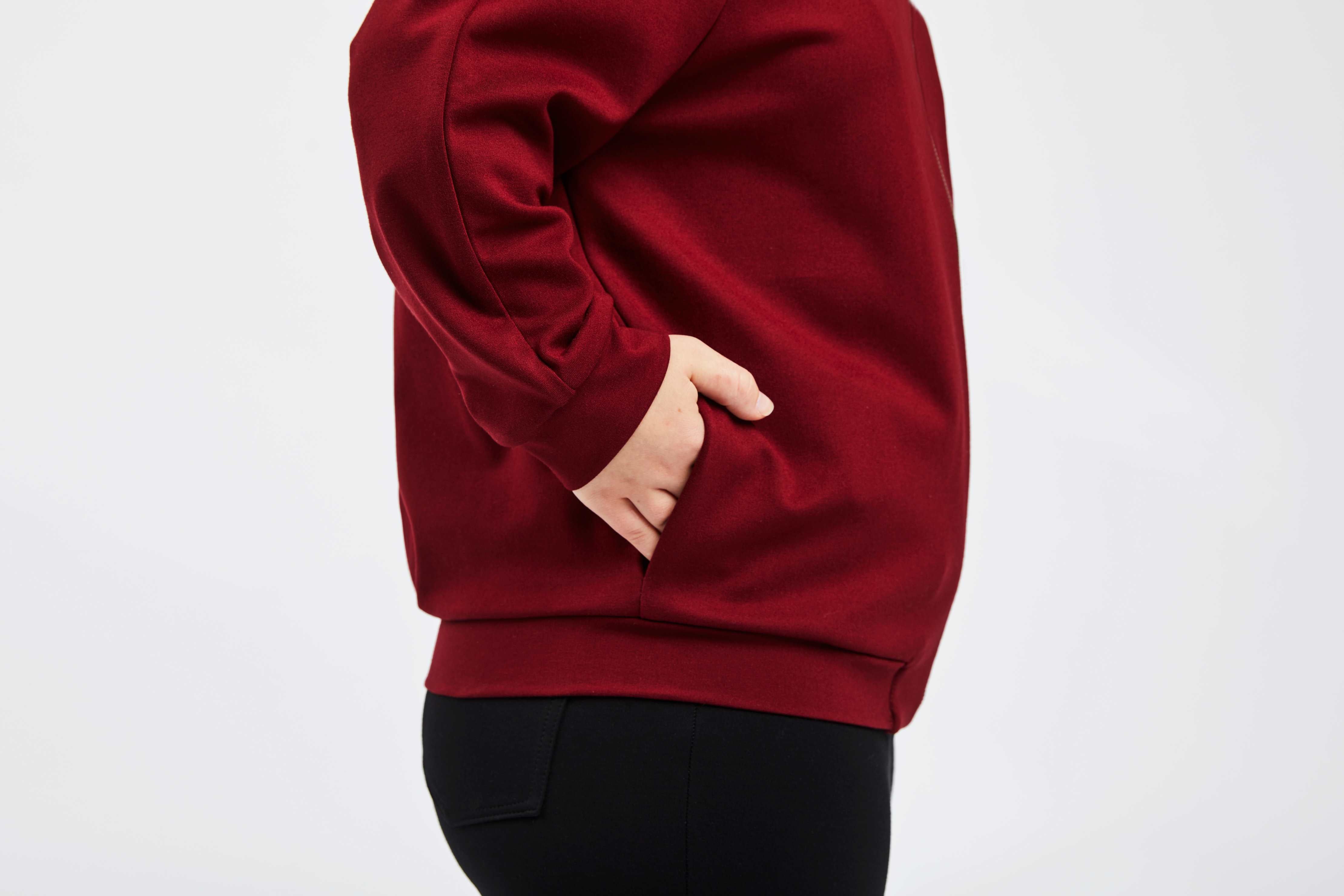 detailed view of hands in pocket of red college jacket