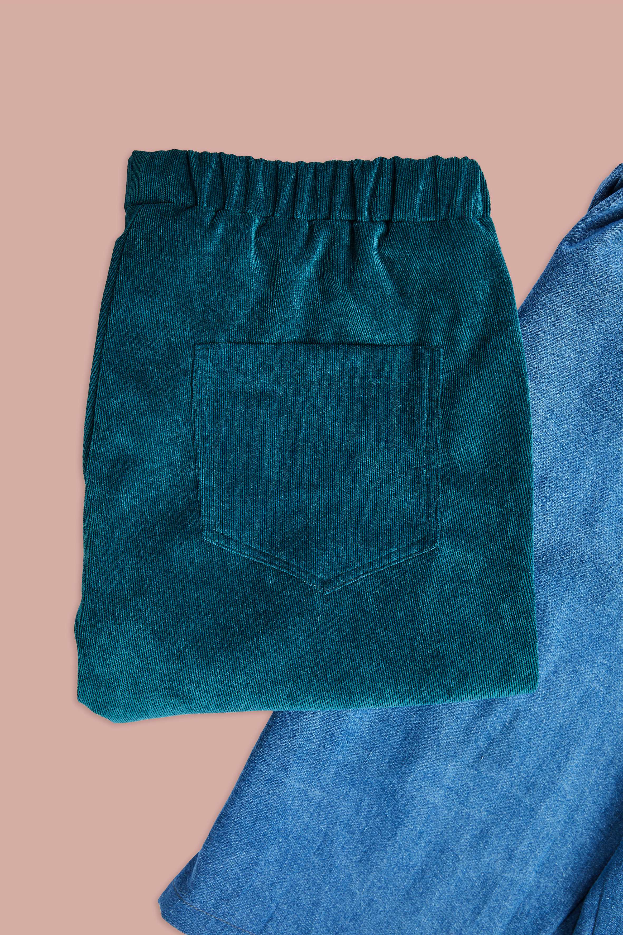 folded up corduroy pants and detailed view of jeans pants