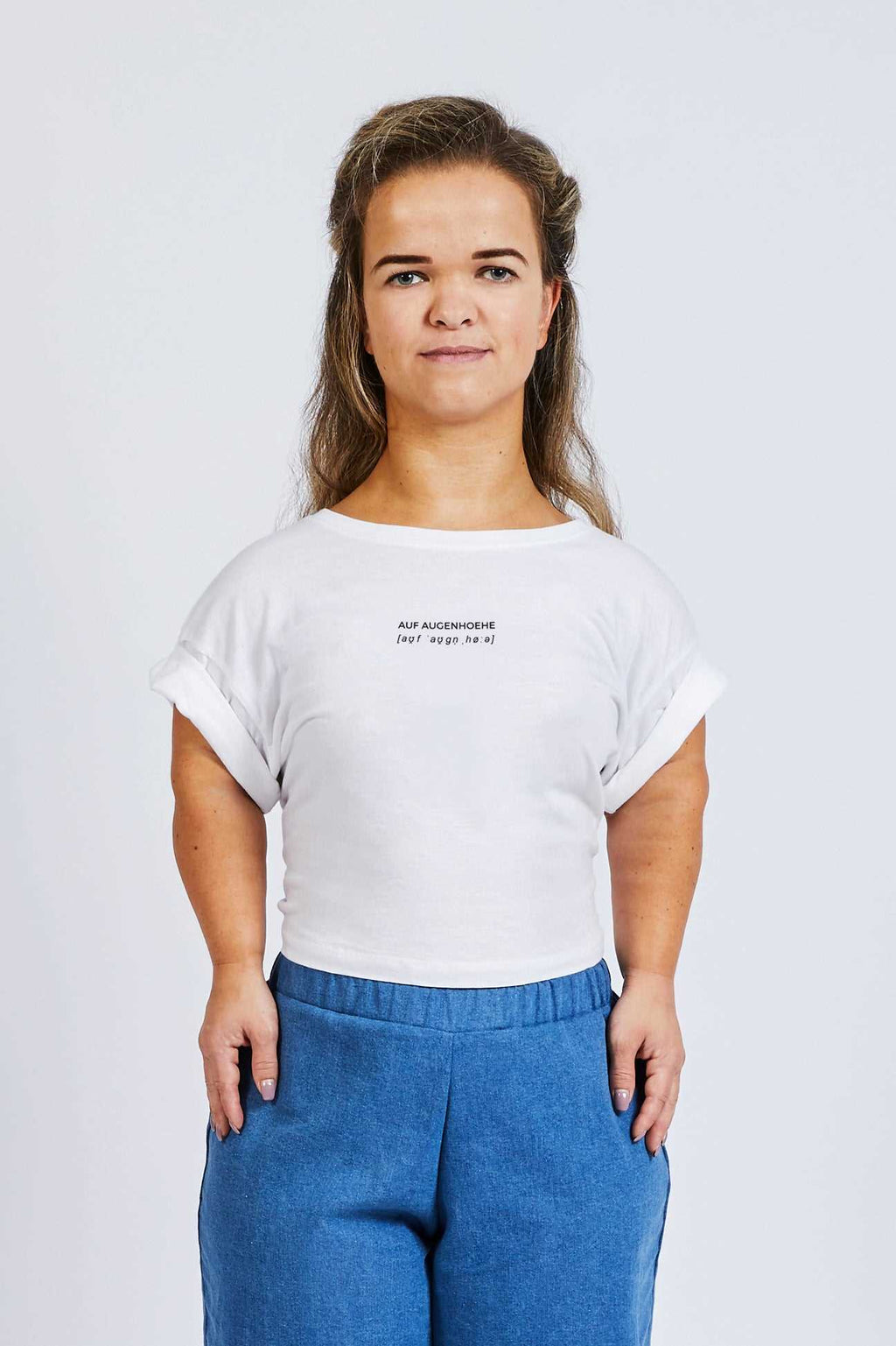 woman with dwarfism wearing a cropped white thsirt with small logo