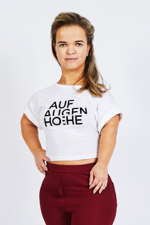 woman with dwarfism wearing white cropped top with big brand logo