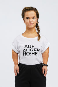 woman with dwarfism wearing white t-shirt with black brand logo
