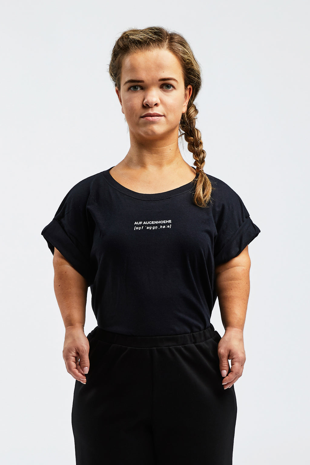 woman with dwarfism wearing a black t-shirt with small white text