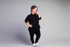 woman with dwarfism wearing black blouse and pants smiling