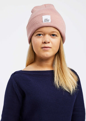 woman with dwarfism wearing a rose coloured beanie