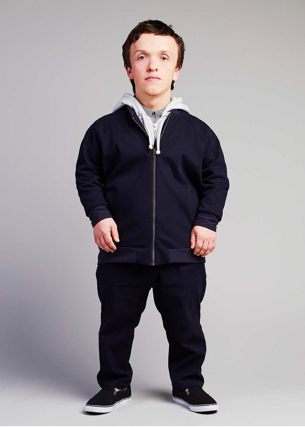 man with dwarfism wearing dark blue college jacket and matching outfit
