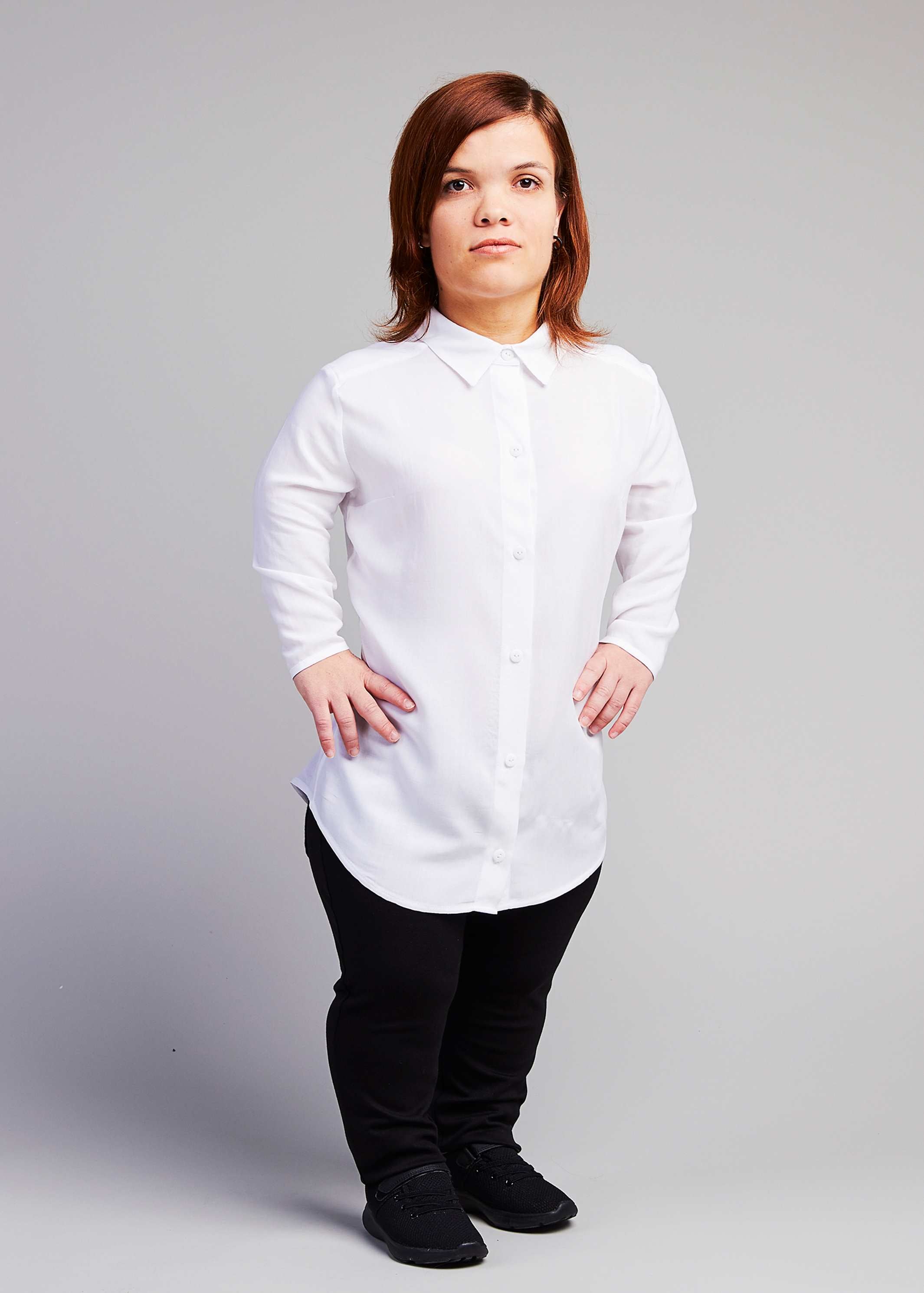 woman with dwarfism wearing white blouse and black pants