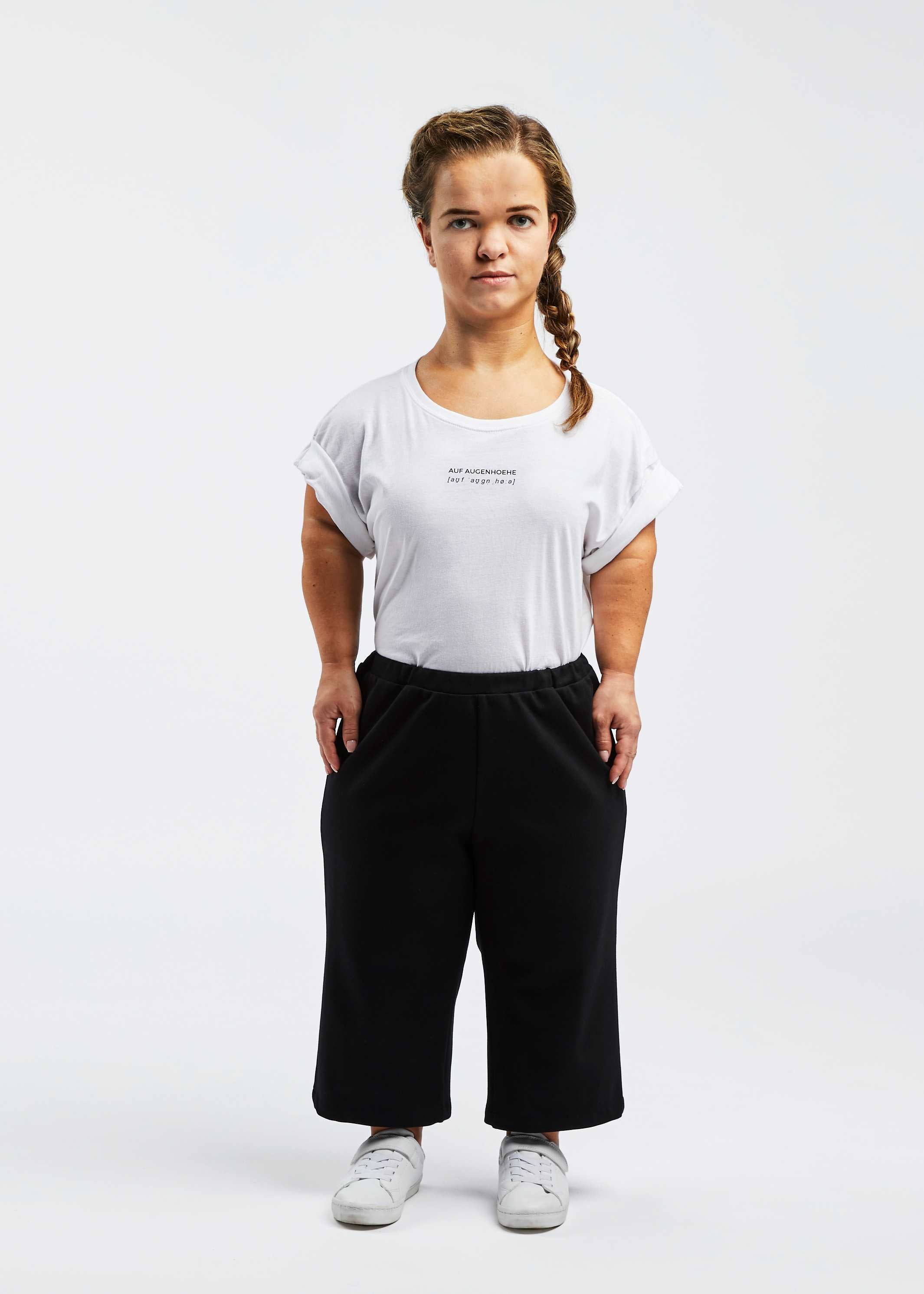 woman with dwarfism wearing black pants and white shirt