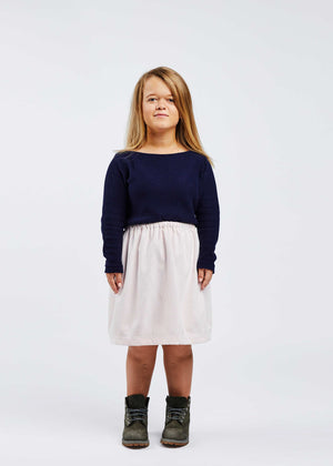 woman with dwarfism wearing white skirt and dark blue pullover