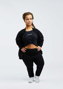 woman with dwarfism wearing black pants and matching top and jacket