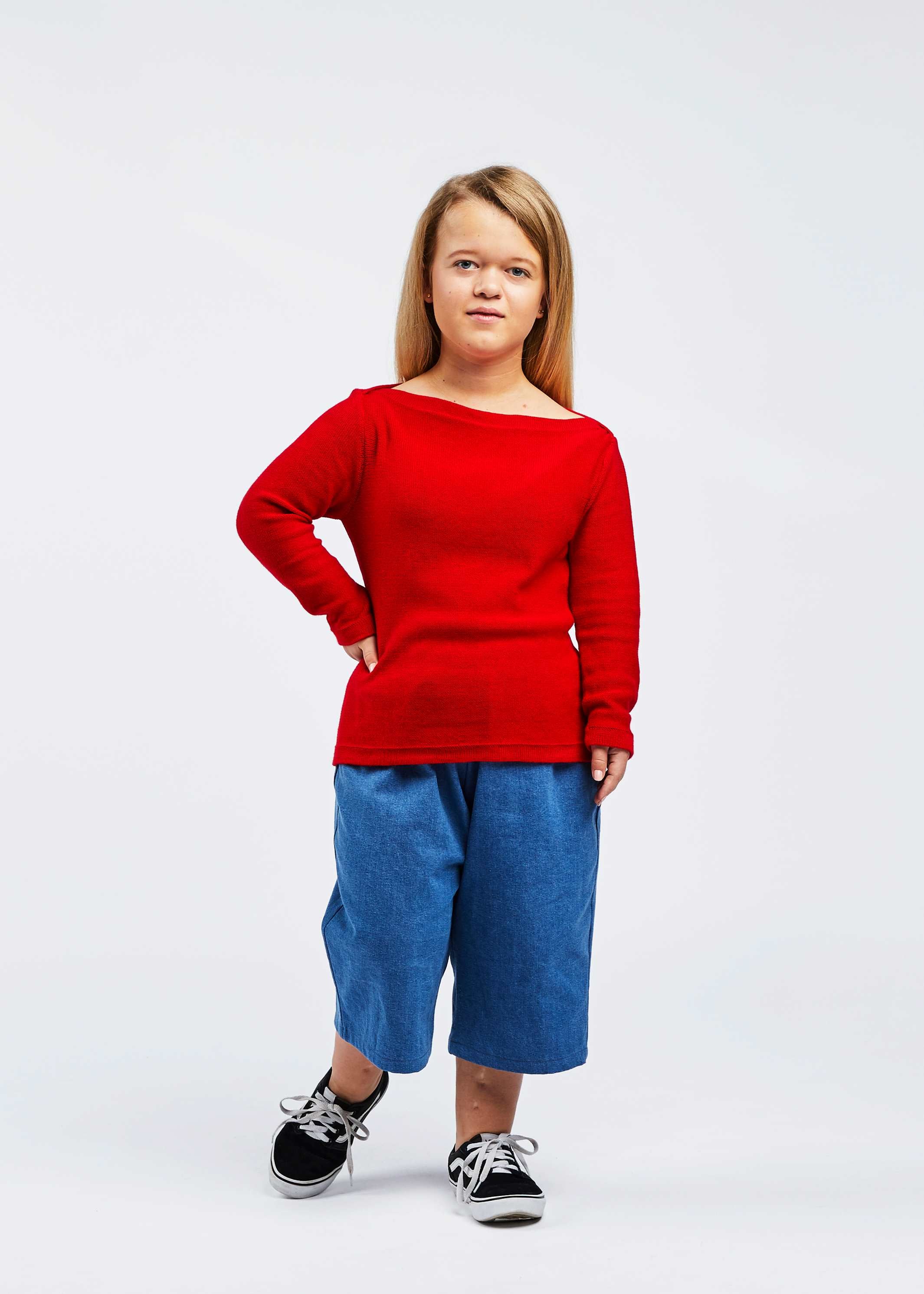 woman with dwarfism wearing red pullover and blue pants