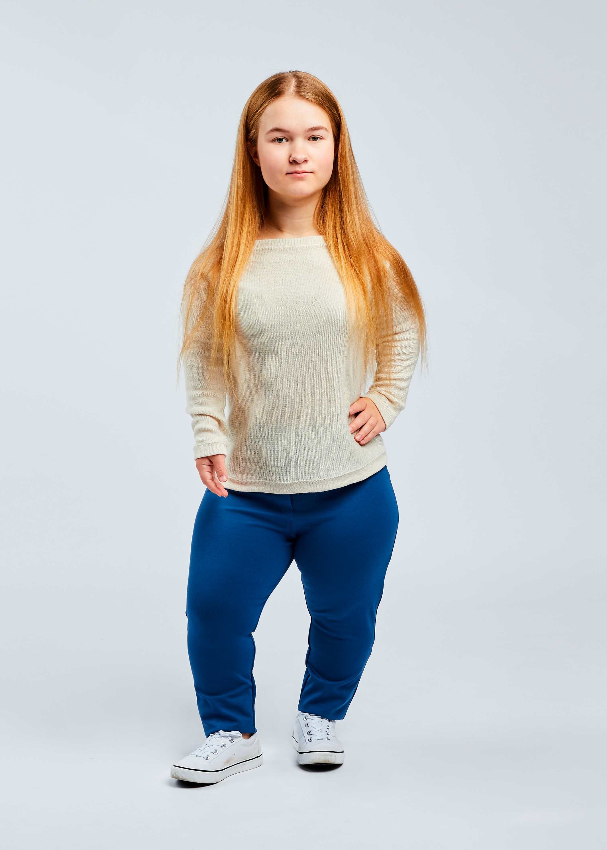 woman with dwarfism wearing blue pants and white pullover