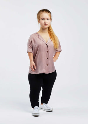 woman with dwarfism wearing short sleeved rose blouse