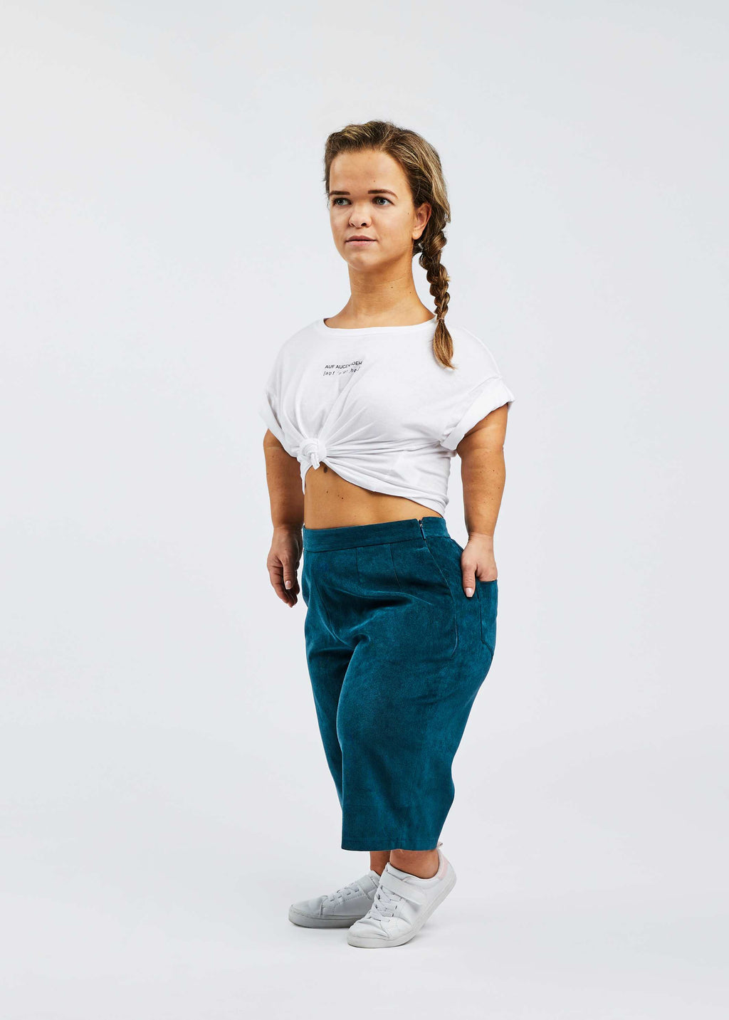woman with dwarfism wearing blue corduroy culottes and white shirt
