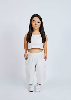 woman with dwarfism wearing white culottes with small dots and matching crop top