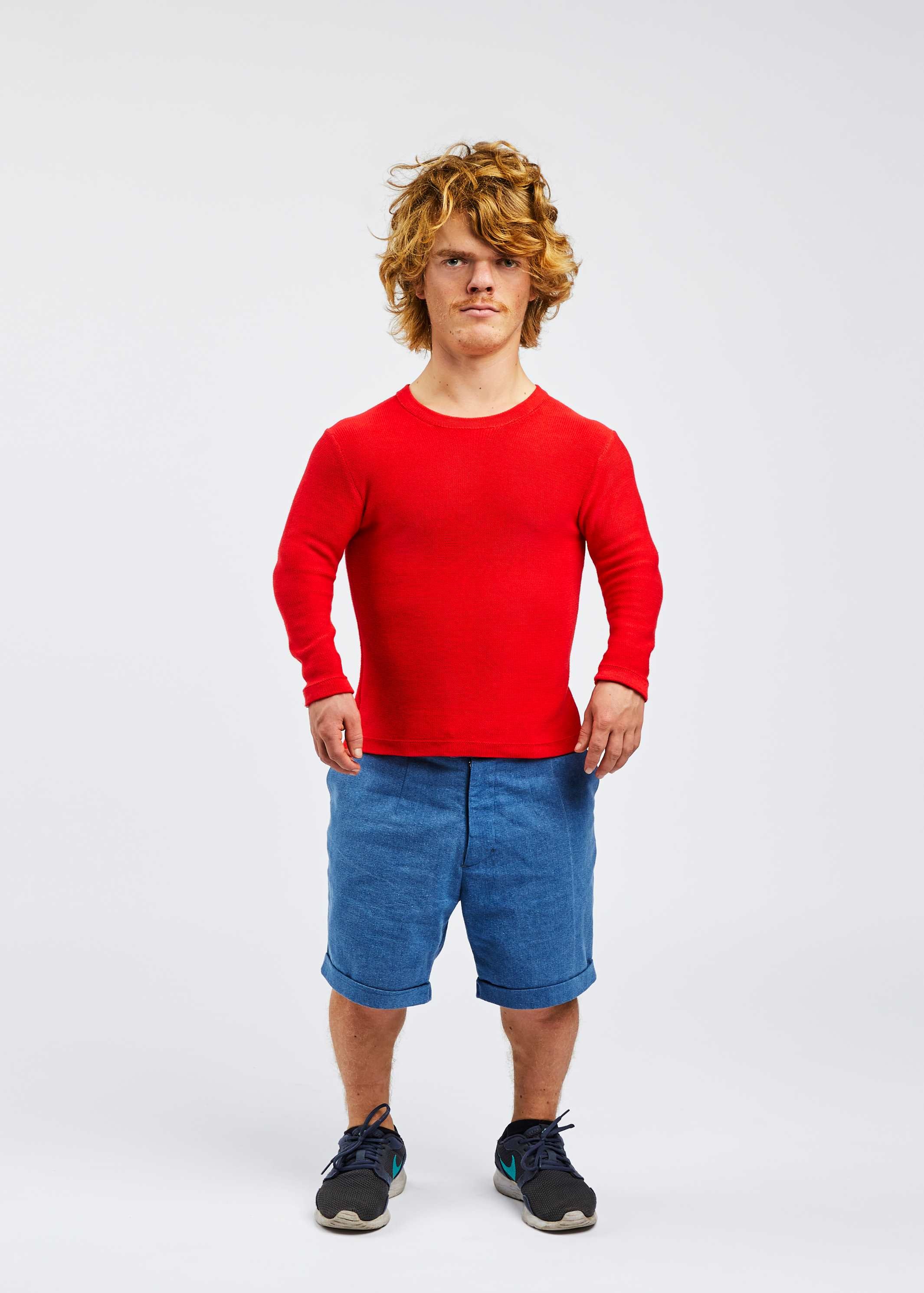 man with dwarfism wearing red pullover and blue shorts