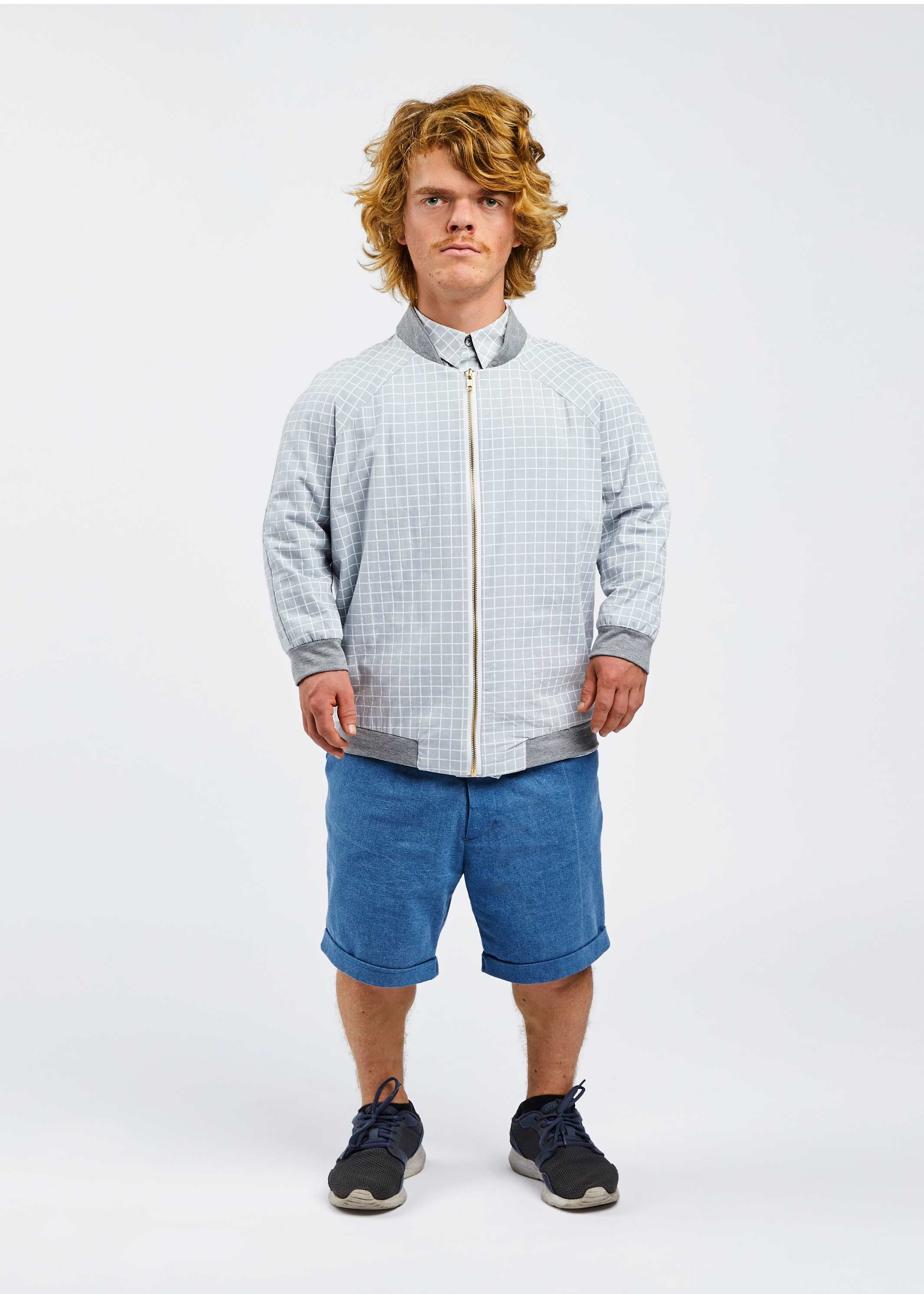 man with dwarfism wearing light blue grid design college jacket and blue shorts