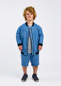 man with dwarfism wearing blue college jacket and shorts